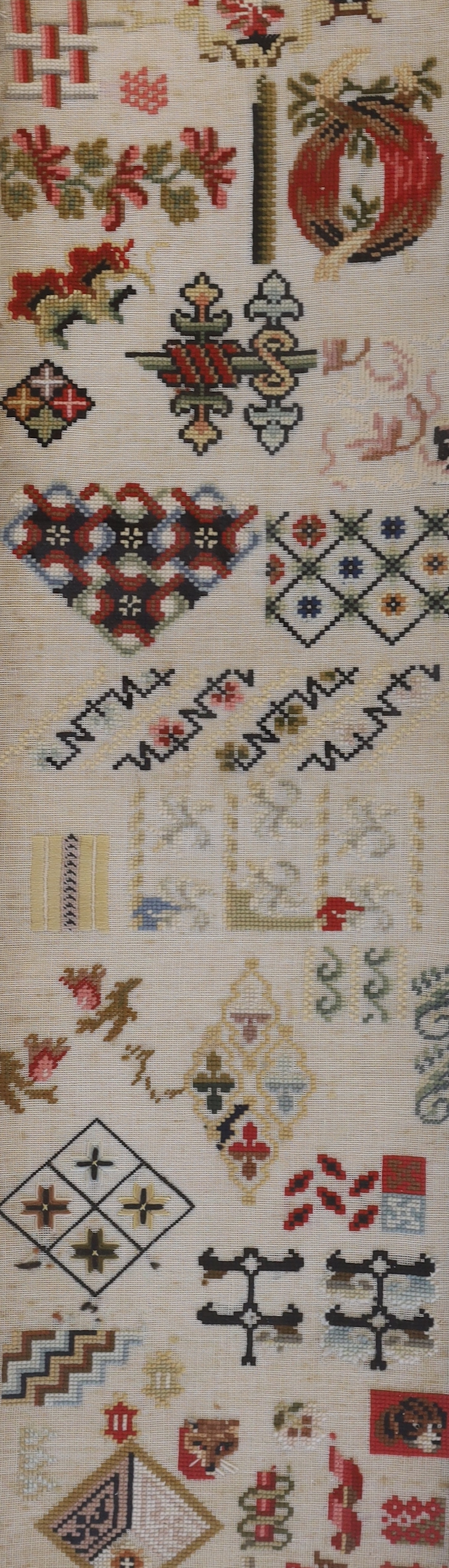 A Regency silk and wool embroidery of a seated boy by a tree and a Victorian spot motif wool-worked sampler, Regency embroidery 29.5cm x 33cm wide